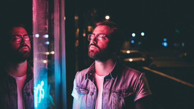 a guy wearing glasses and lookin at RGB lighting