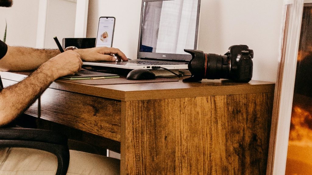 A guy using a desk and the desk is the main focus where is a camera on the top of this desk