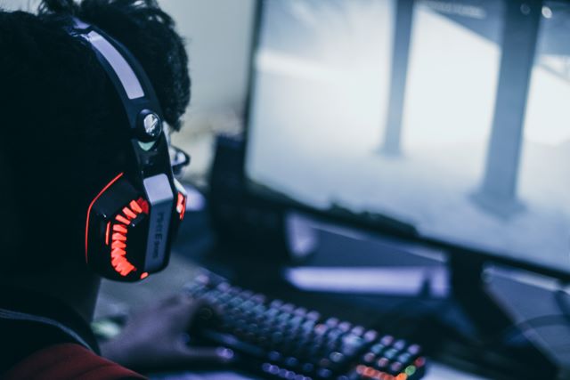A guy playing game with a RGB keyboard